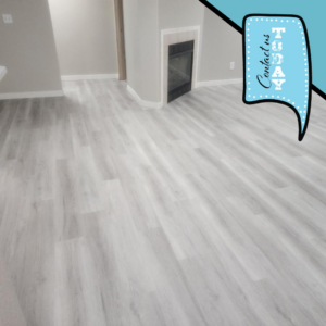 Light grey laminate flooring installed in a room with a fireplace by Dany's contractors LLC in Vancouver, WA.