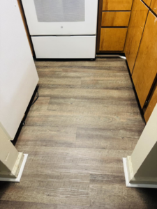 New light wood-look laminate flooring installed in a kitchen by NGU Contracting Solutions LLC in Albany, GA.