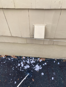 Lint and a dryer vent cleaning brush on the ground after a thorough cleaning by DiEduardo Home Services LLC in Edison, NJ.