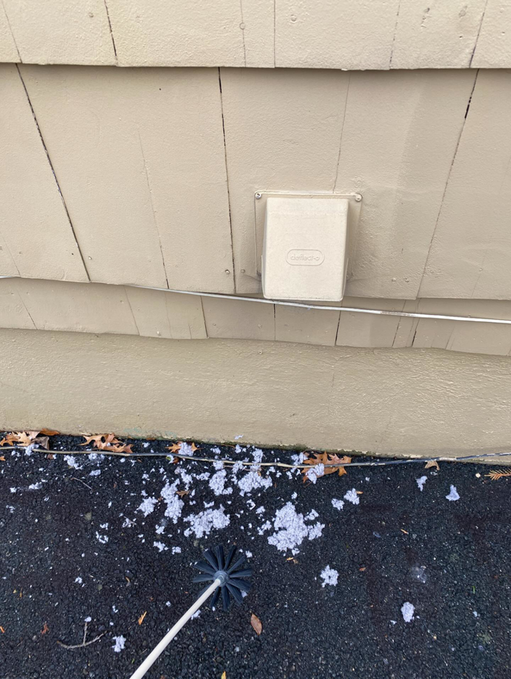 Lint and a dryer vent cleaning brush on the ground after a thorough cleaning by DiEduardo Home Services LLC in Edison, NJ.