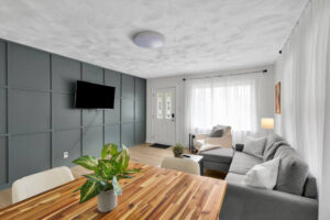 A living room featuring a decorative accent wall, mounted TV, and new flooring installed by Imperial Access Contracting in Evansville, IN.