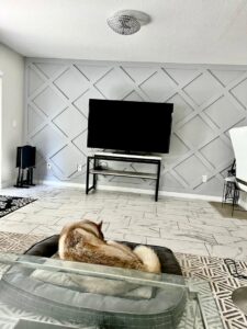 A living room featuring a stylish geometric accent wall and modern tile flooring, completed by SD Masters in Miami, FL.