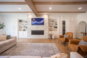 A living room featuring custom built-in shelving, a modern fireplace, and decorative wood beams by Legacy Builders Group in Cincinnati, OH.