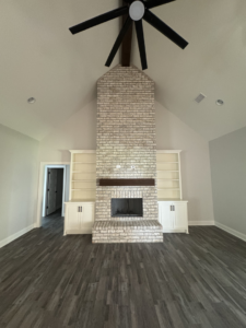 Living room with a new ceiling fan and custom built-in shelves installed by Adamson Construction Group in Salem, AL.