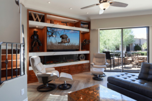 A modern living room featuring a custom built-in entertainment center and fireplace by Homework Remodels in Phoenix, AZ.