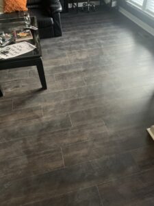 A living room with newly installed dark laminate flooring by Glenni Floors LLC in Roswell, GA.