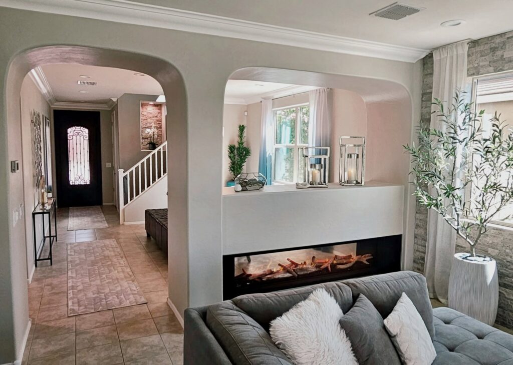 A modern living room with a built-in fireplace and decorative archways, showcasing renovation work by American Wolf Construction in Mesa, AZ
