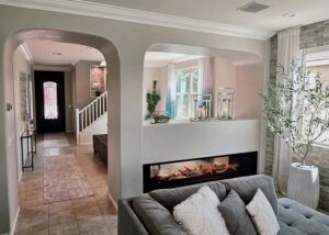 A modern living room with a built-in fireplace and decorative archways, showcasing renovation work by American Wolf Construction in Mesa, AZ