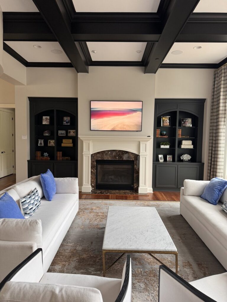 A stylish living room remodel with a white fireplace, dark built-in cabinets, and a mounted TV, completed by Inova Builds in Bloomington, MN.