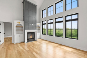 Living room with a modern fireplace and light hardwood floors by WoodHaven Floor Refinishing in Georgetown, KY.