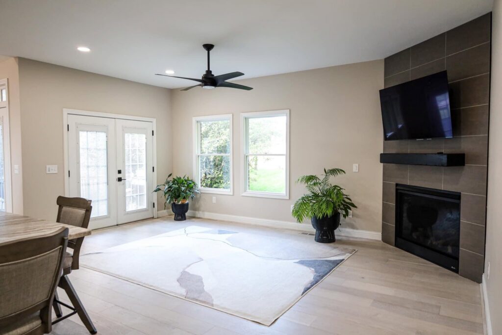 A modern living room featuring a newly installed tiled fireplace and mounted TV by Kore Construction LLC in Cincinnati, OH.