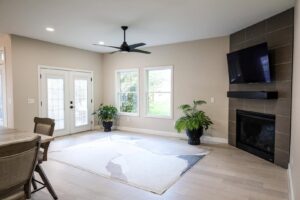 A modern living room featuring a newly installed tiled fireplace and mounted TV by Kore Construction LLC in Cincinnati, OH.