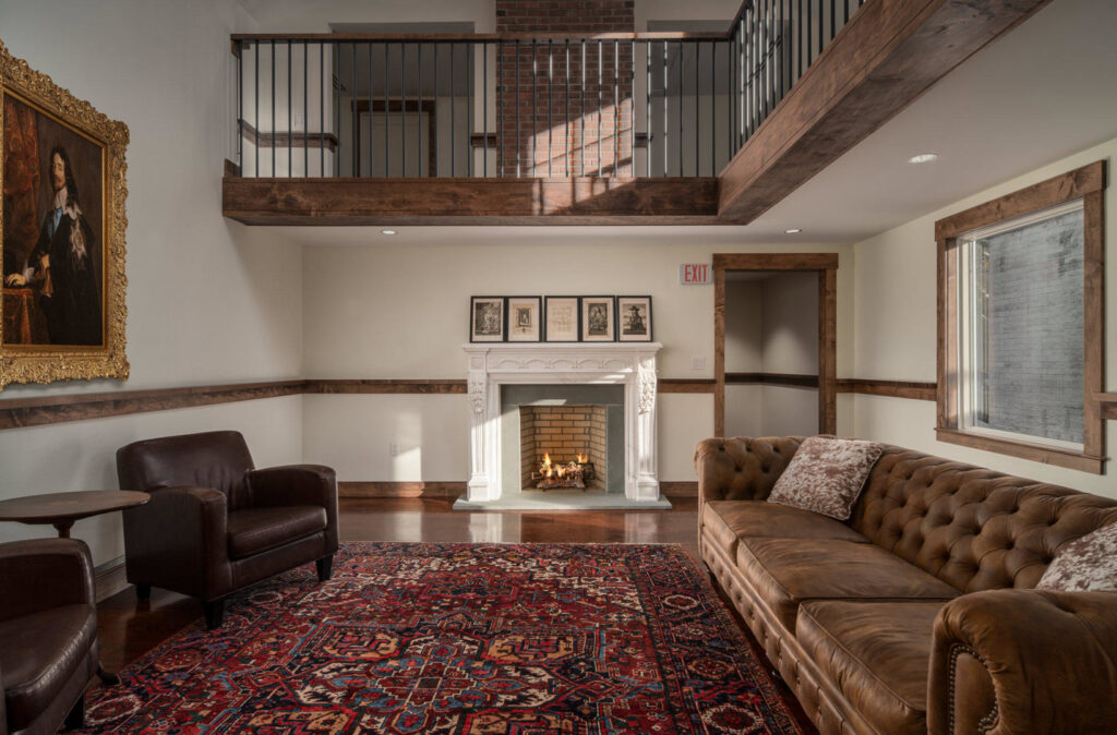 A renovated living room featuring a cozy fireplace and exposed wood beams by Santoro Home Improvements in Wallingford, CT.