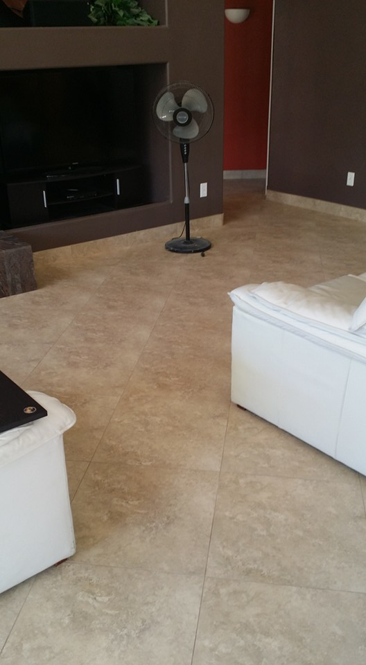 A living room with newly installed natural stone floor tiles by Gudiño's Tile and Natural Stone in Glendale, AZ