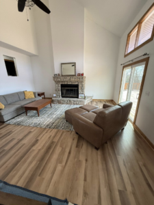 A newly installed hardwood-style floor and trim in a living room by M Squared Construction LLC in Tonganoxie, KS.