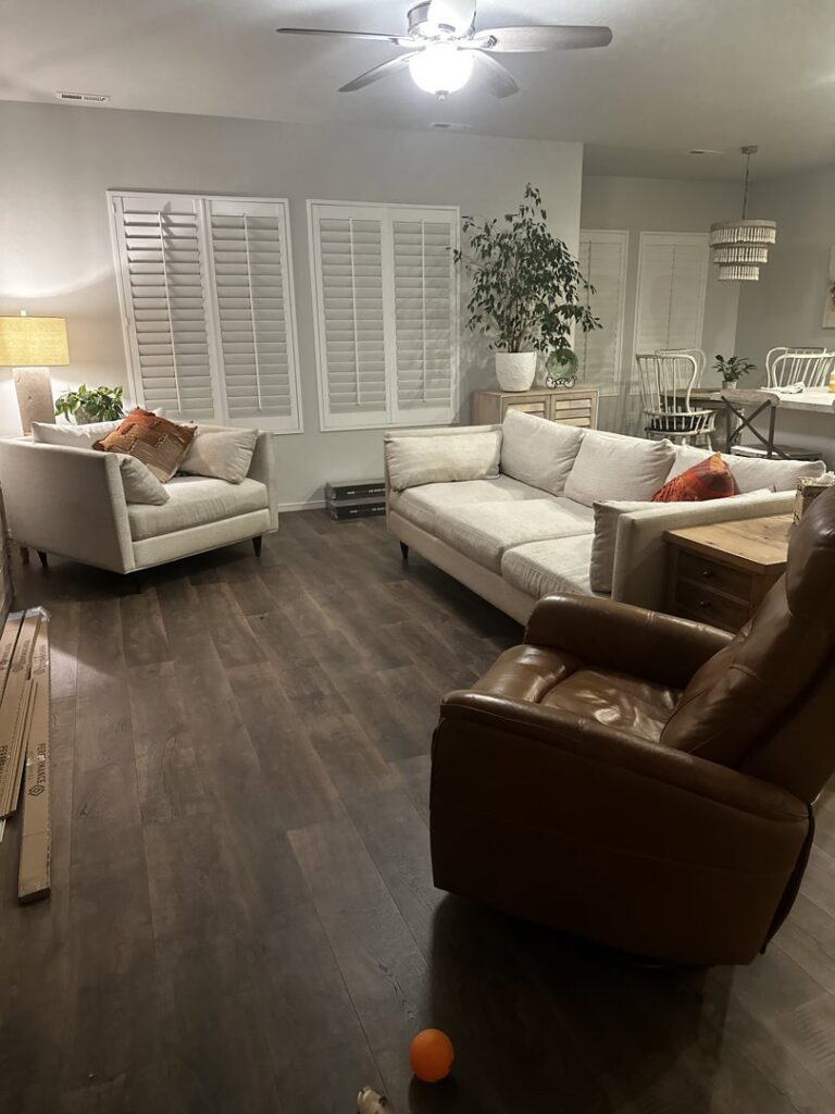 A living room with newly installed flooring and window shutters by Precision Home Solutions in Santa Fe, TN