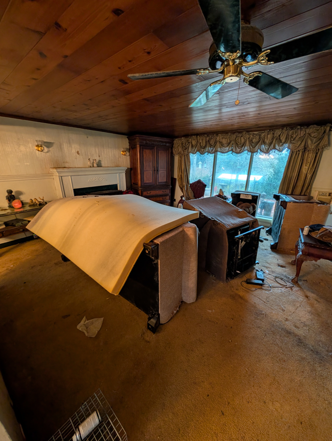 A living room with old, disassembled furniture and clutter, ready for cleanout by Patriot Hauling & Junk Removal LLC in Salem, OR.