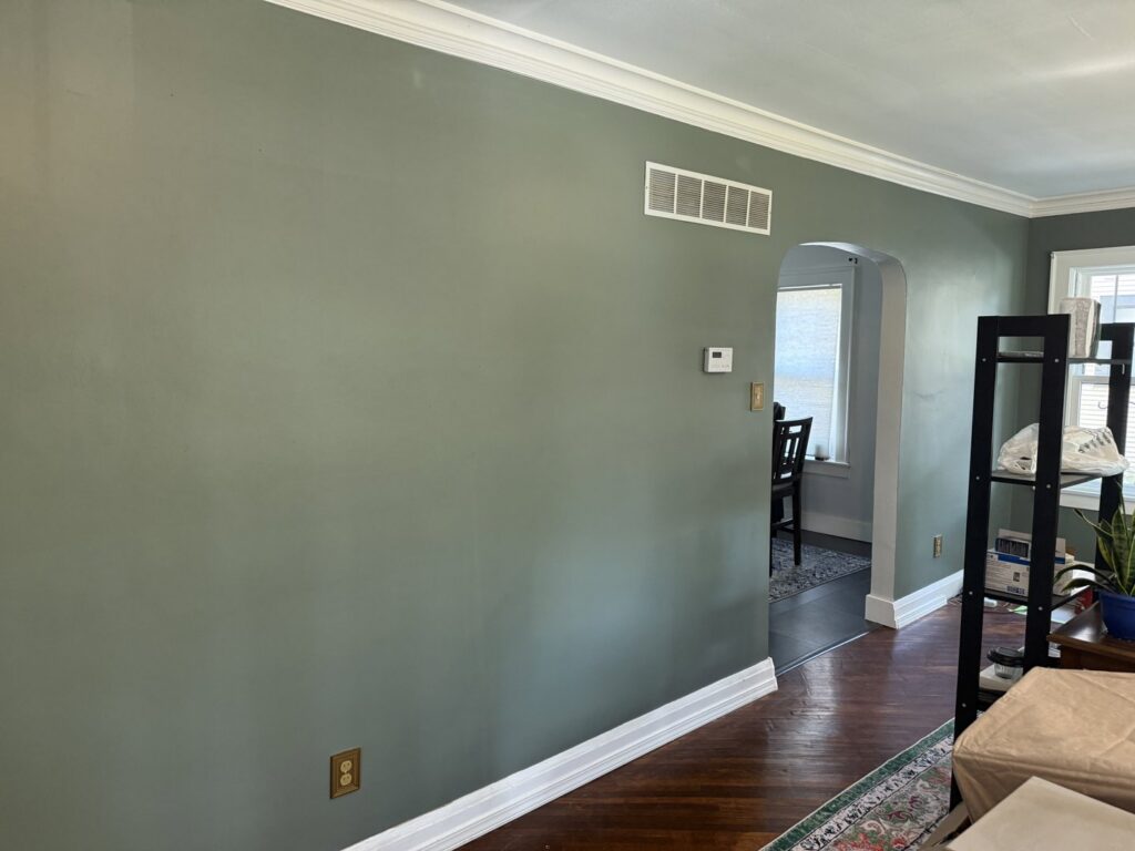 A finished living room with elegant green painted walls and white trim by FG Drywall, Finishing and Painting in Champaign, IL.