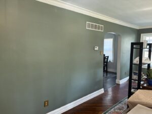 A finished living room with elegant green painted walls and white trim by FG Drywall, Finishing and Painting in Champaign, IL.
