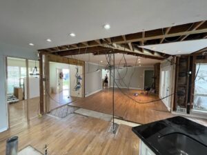 Living room and kitchen wall removal renovation by Load Bearing Wall Pros in Plano, TX, with exposed ceiling.