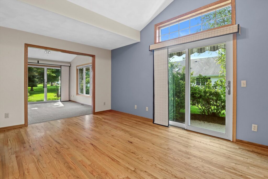 A bright living room featuring light hardwood flooring and a blue accent wall, installed by Nelson Hardwood Flooring in Madison, WI.