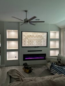 A newly installed living room media center with built-in shelves and electric fireplace by PaRu Construction LLC in San Antonio, TX