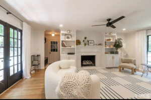 A renovated living room featuring a fireplace, custom built-in shelves, and new hardwood flooring installed by Pro Finishes NC, LLC in Raleigh, NC.