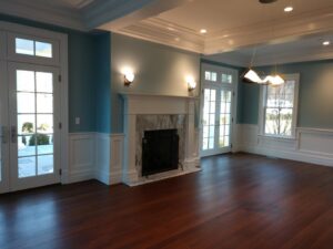 A renovated living room featuring a new fireplace, hardwood floors, and wainscoting by Santoro Home Improvements in Wallingford, CT.