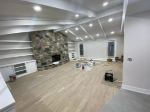 A living room undergoing renovation with a stone fireplace and built-in shelves, managed by Hazelton Services Inc in Warren, MI.