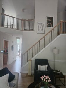 Living room with new flooring and staircase railing completed by Santizo Flooring & Painting in Raleigh, NC.