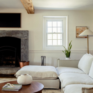 Living room featuring a rustic stone fireplace and exposed wooden beam installed by Brentwood Builders Inc. in Lancaster, PA.
