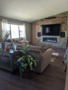 A cozy living room featuring a stone-faced fireplace and a mounted television, completed by The Foundation Guys in Lakewood, CO