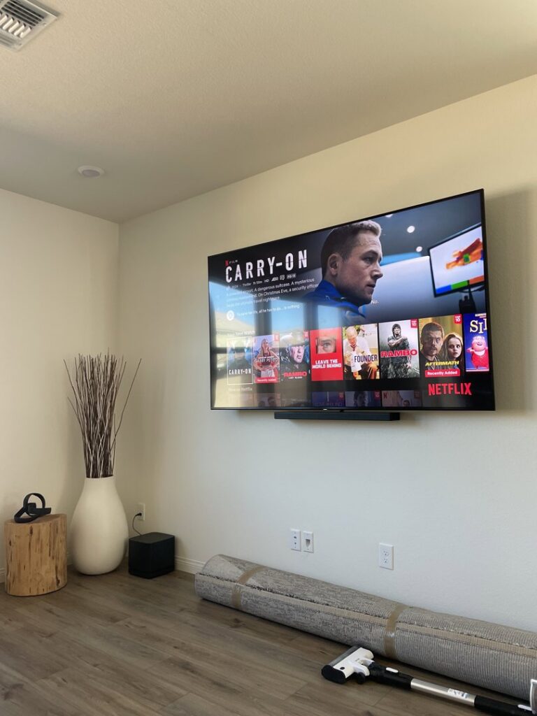 A modern living room featuring a wall-mounted TV and soundbar, installed by Tech Handy-Las Vegas in North Las Vegas, NV.