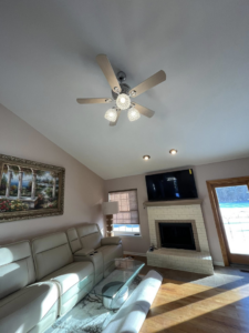 A living room featuring a mounted TV, ceiling fan, and recessed lighting installed by GOAT Tv Mounting & Home Improvement L.L.C in Toledo, OH.
