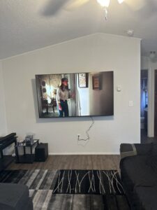 A flat-screen television professionally mounted on a living room wall by K-Way's Handyman Services in Lincoln, NE