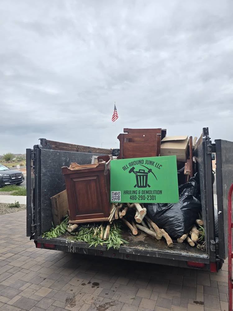 A dump trailer loaded with various junk items and a sign for ALL around junk, LCC, after a successful removal job in Mesa, AZ.