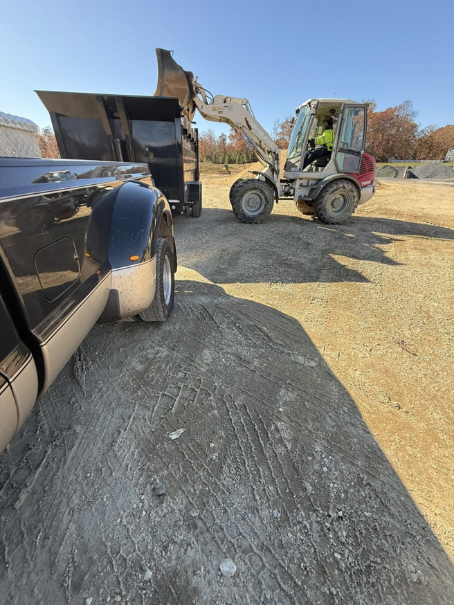 A front-end loader filling a junk removal trailer with debris, demonstrating services by Freedom Hauling in California, MD.