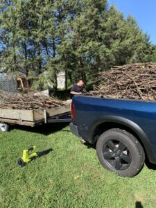 A worker loading tree branches and yard waste into a trailer for removal by Junk Lockdown LLC in Lancaster, PA.