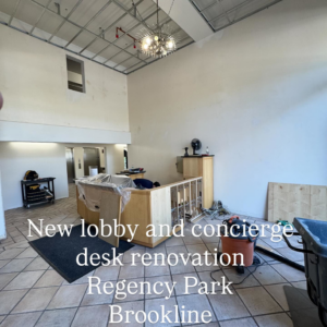 A lobby renovation in progress with exposed ceiling and partially built desk by Markos Construction in Cambridge, MA.