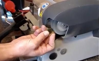 A locksmith precisely cutting a new key using a professional key duplication machine at MX Locksmith in North Las Vegas, NV.