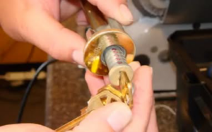 A locksmith rekeying a door lock cylinder with a new key, ensuring security for clients of MX Locksmith in North Las Vegas, NV.