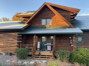 The exterior of a log cabin home with tools on the porch, indicating maintenance or repair work by Building Arts by Jimmy Z in Cassville, WI.