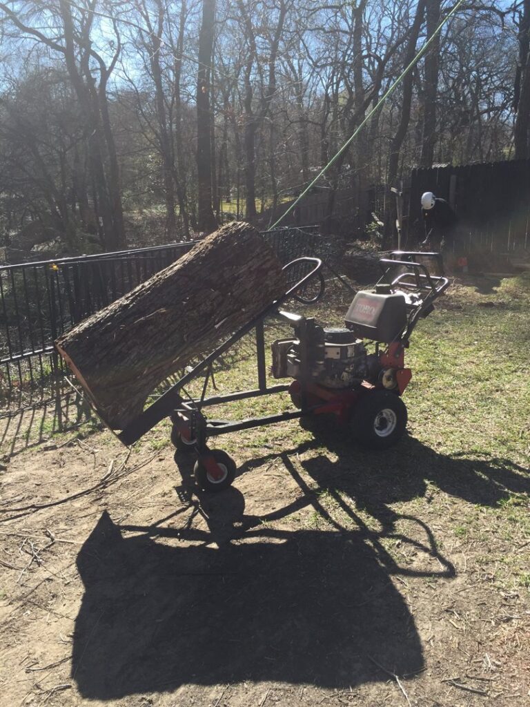 A specialized log lifter moving a heavy tree log, demonstrating efficient cleanup by Anderton Tree Service in Fort Worth, TX