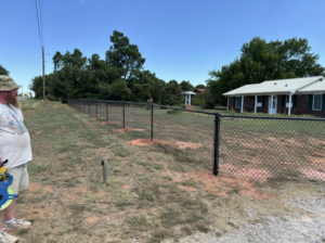 A long stretch of newly installed black chain-link fence along a property line by Herron Fencing LLC in Shawnee, OK.