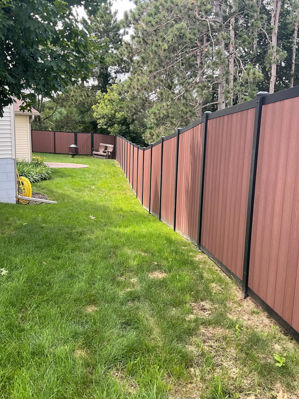 A long brown privacy fence installed along a residential property by Cyclone Fence in Somerset, WI.