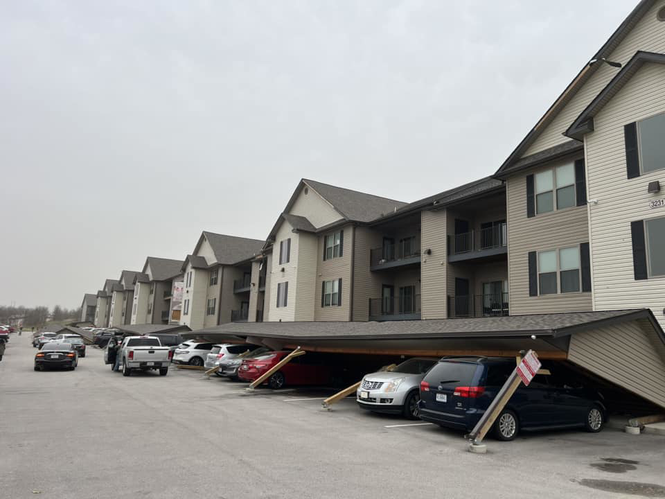 A long section of a collapsed carport structure at an apartment complex, requiring extensive repair by Larson Exteriors in Sunset Hills, MO.