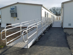 Extended metal access ramp with handrails leading to a portable building, installed by Northwest Access Products LLC in Castle Rock, WA.