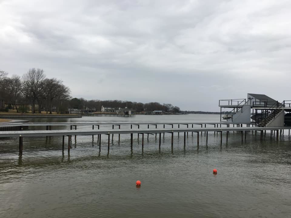 A long pier extending to a boat dock on a lake, built by TYCO Roofing & Construction LLC in Allen, TX.