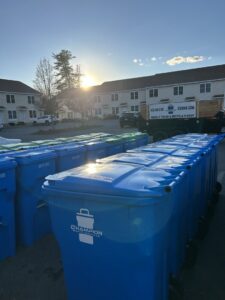 A long row of blue residential trash and recycling bins provided by Champion Waste Services in Londonderry, NH.