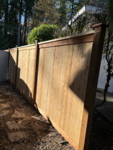 A long section of a newly installed wooden fence providing privacy and security by Guzmanremodeling LlC in Renton, WA.